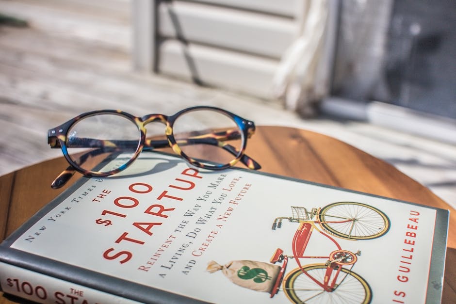 Close-up of a book and eyeglasses on a table, perfect for study or leisure reading.